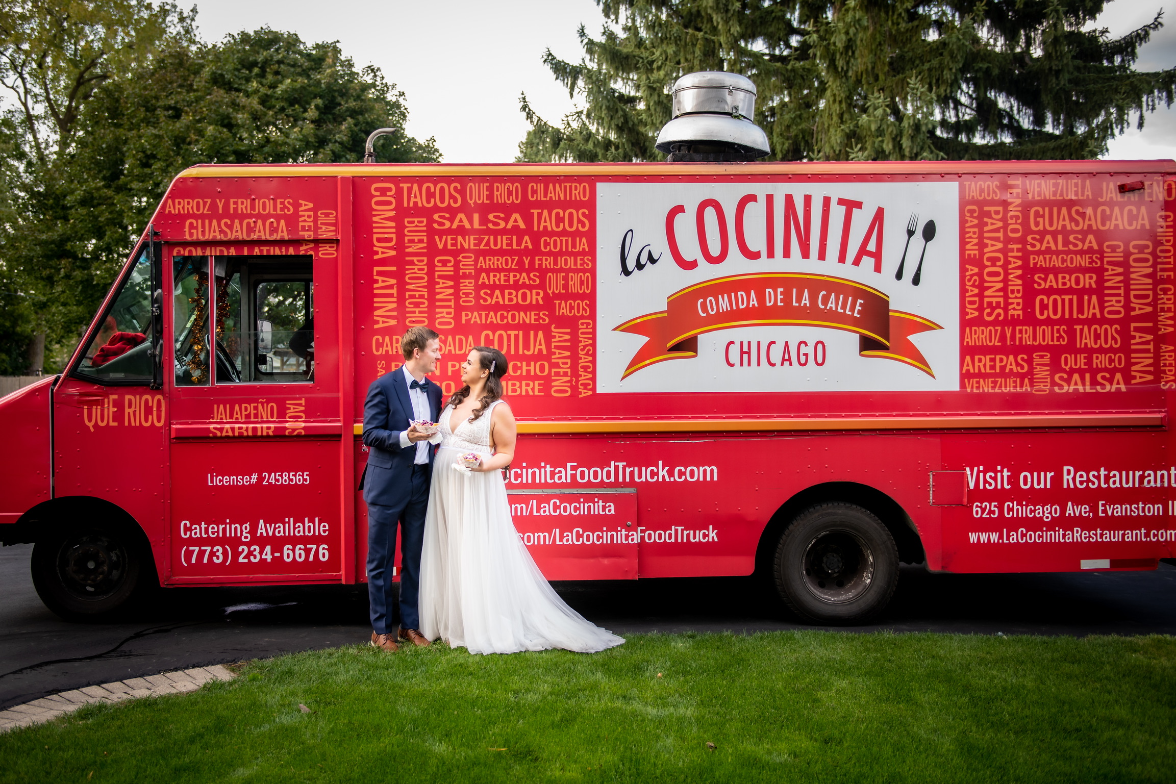 Red food truck La Cochinita with a bride in white and a groom in a suit in front